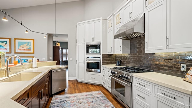 kitchen with sink, white cabinets, appliances with stainless steel finishes, and pendant lighting