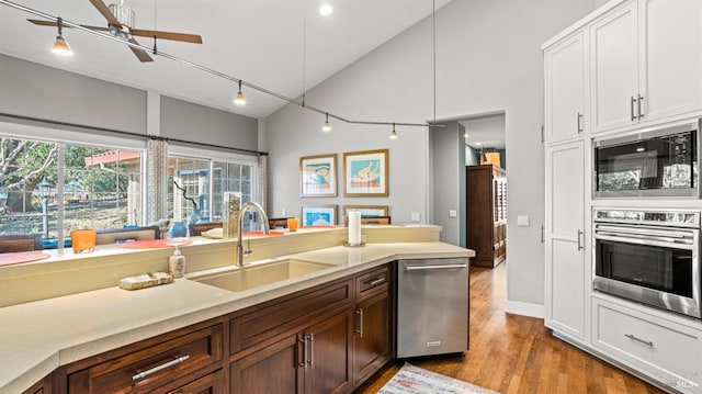 kitchen featuring white cabinets, stainless steel appliances, sink, ceiling fan, and light hardwood / wood-style flooring