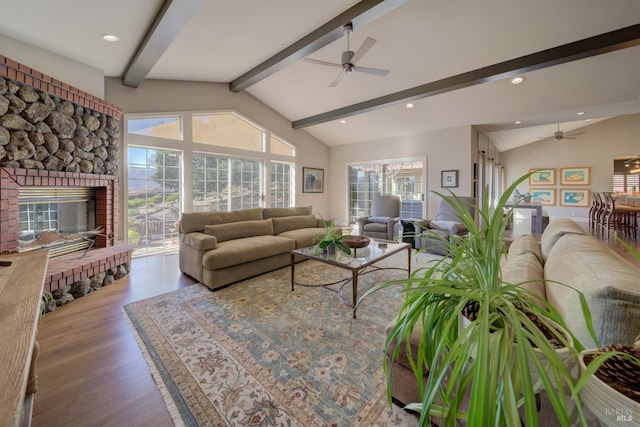 living room featuring a brick fireplace, hardwood / wood-style flooring, lofted ceiling with beams, and ceiling fan