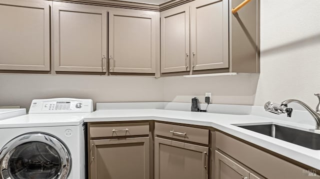 clothes washing area featuring sink, cabinets, and washing machine and clothes dryer