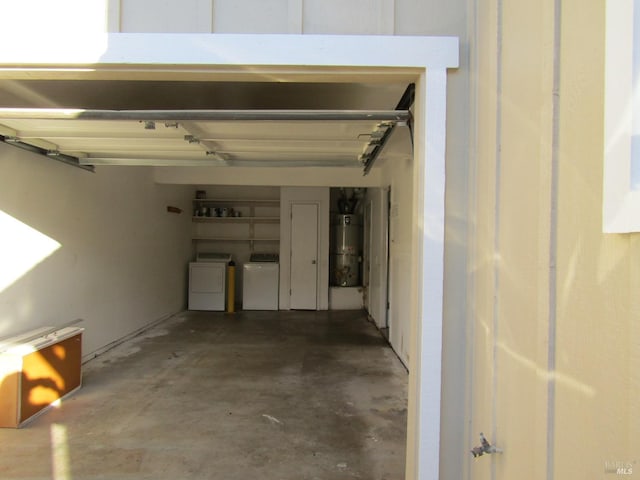 garage with washing machine and dryer and strapped water heater