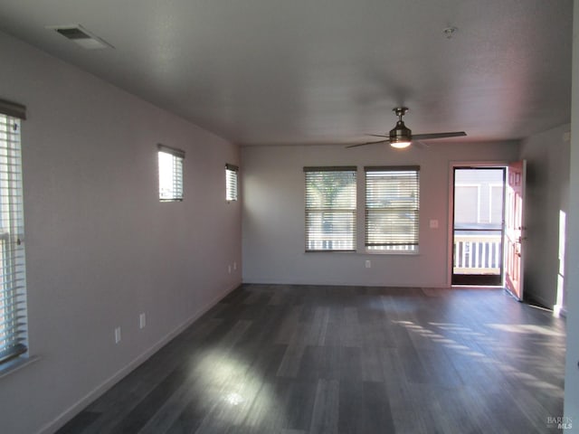 unfurnished room featuring ceiling fan, a wealth of natural light, and dark hardwood / wood-style floors