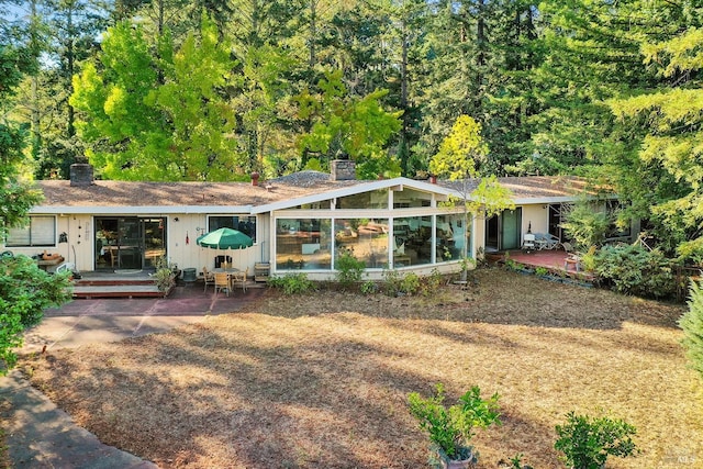 back of property featuring a sunroom and a patio area