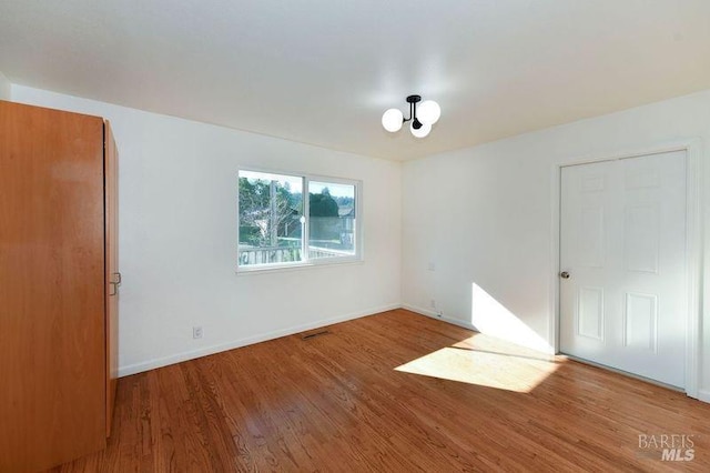 unfurnished room with hardwood / wood-style flooring