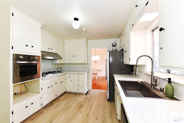 kitchen featuring sink, white cabinets, appliances with stainless steel finishes, and light hardwood / wood-style flooring