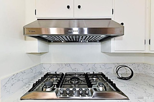 details featuring white cabinetry, stainless steel gas cooktop, and extractor fan