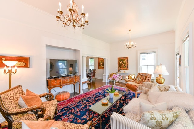 living room featuring hardwood / wood-style flooring, crown molding, and a chandelier