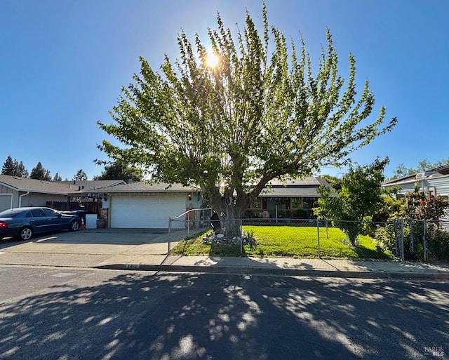 obstructed view of property featuring an attached garage, driveway, and fence