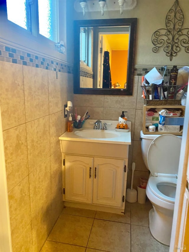 bathroom with tile patterned floors, vanity, toilet, and tile walls