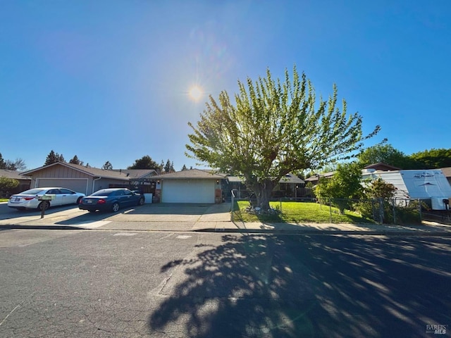 view of front of property featuring a garage, driveway, and fence