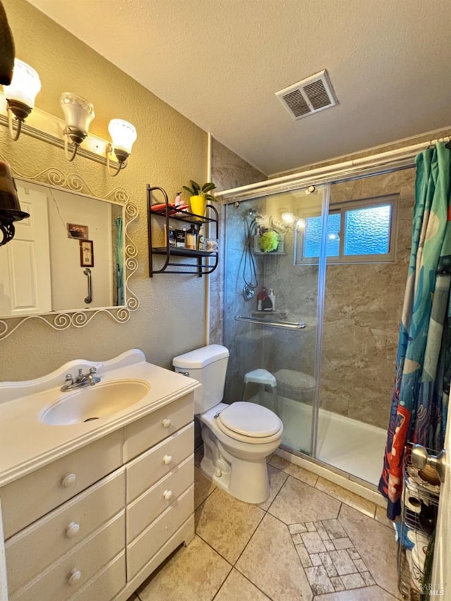 bathroom with a shower stall, a textured ceiling, a textured wall, and visible vents