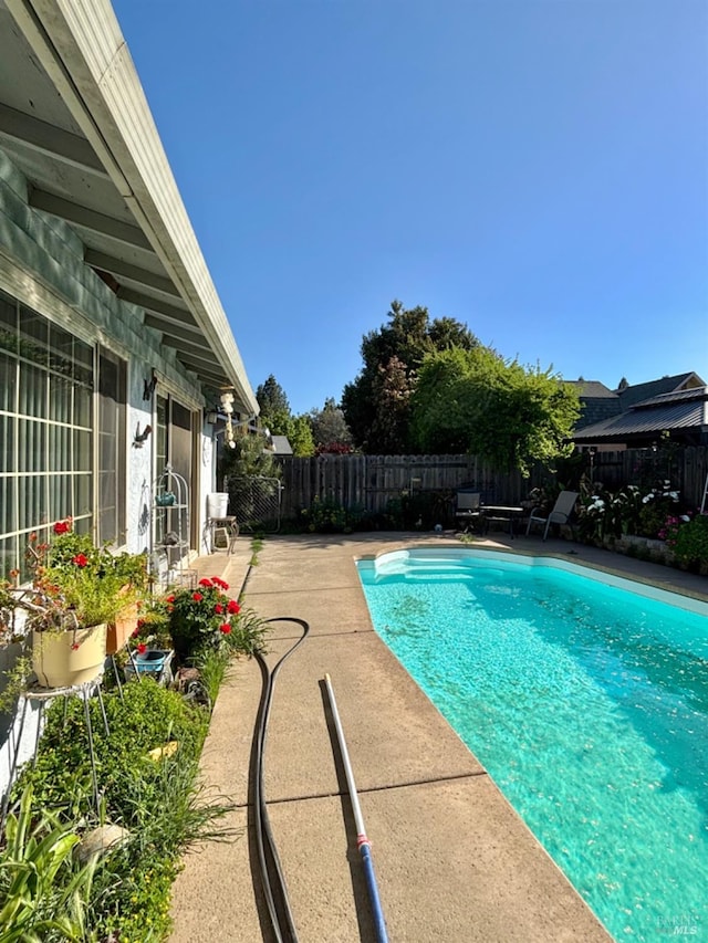 view of swimming pool featuring a fenced backyard, a fenced in pool, and a patio