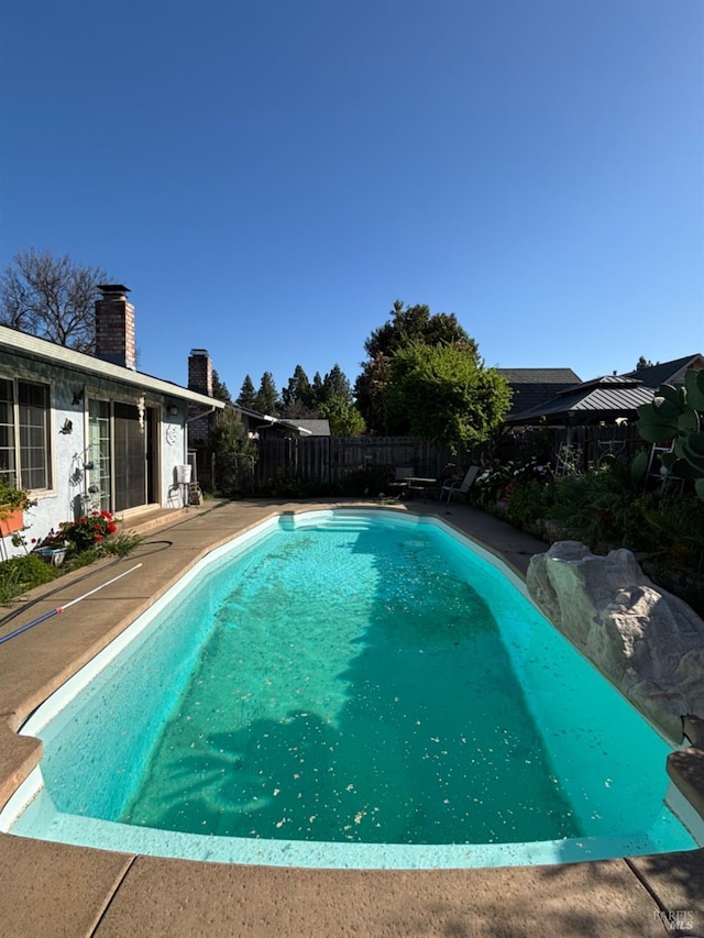 view of swimming pool with a fenced backyard and a fenced in pool
