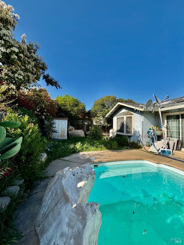 pool featuring an outdoor structure and a storage unit