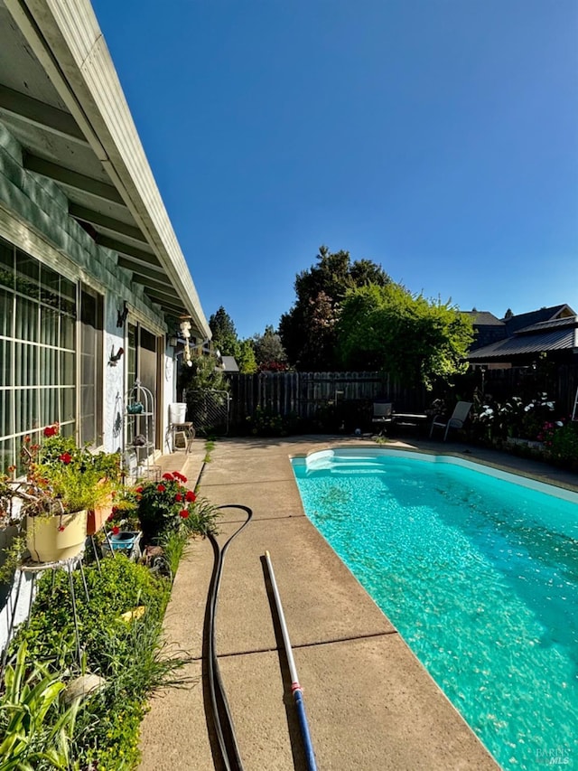 view of swimming pool with a fenced in pool, a fenced backyard, and a patio