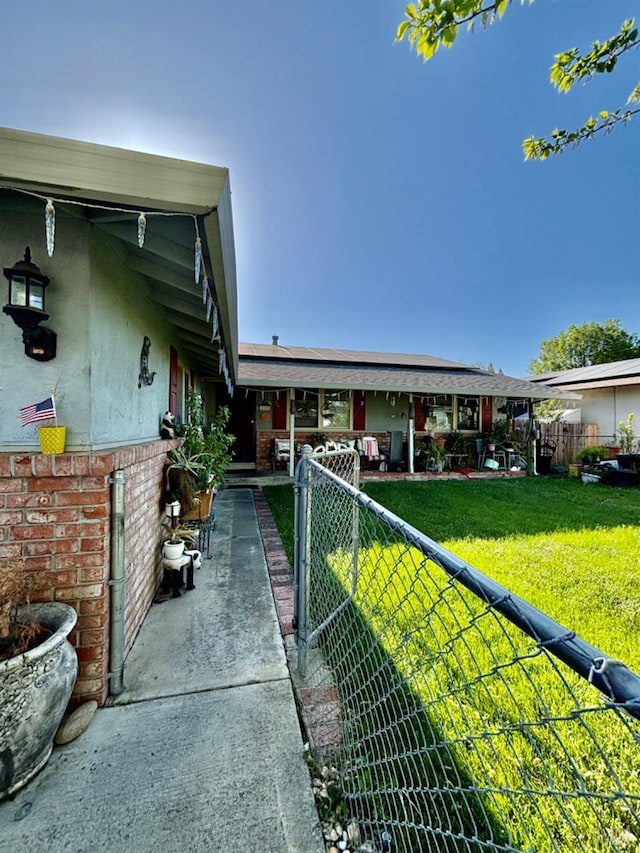 exterior space with a front lawn, fence private yard, and brick siding