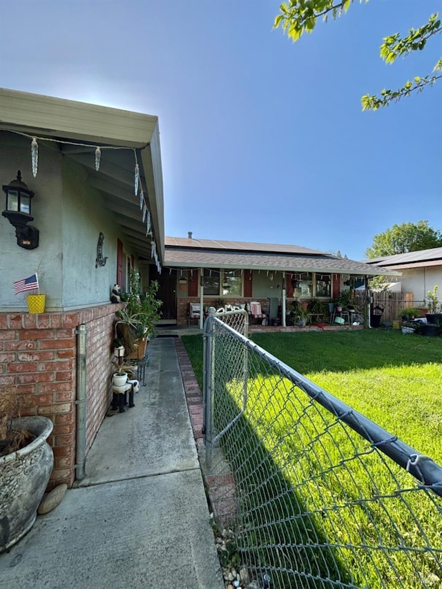 view of front facade with fence, a front lawn, and brick siding