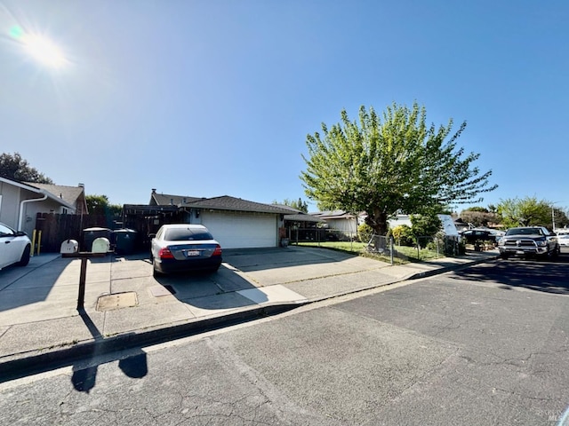 view of front of property with an attached garage, driveway, and fence