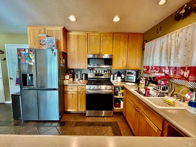 kitchen with light countertops, a sink, recessed lighting, and appliances with stainless steel finishes