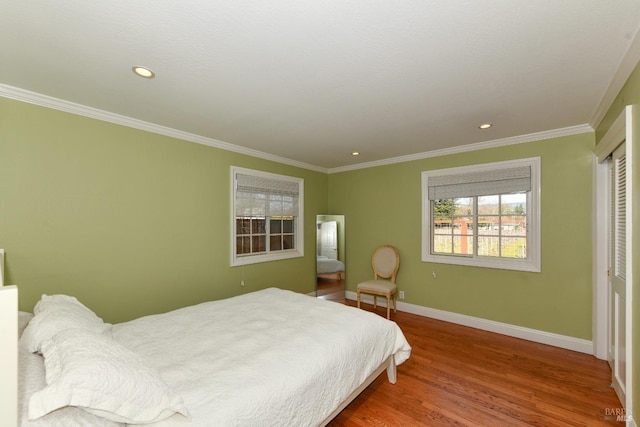 bedroom featuring wood-type flooring, a closet, and ornamental molding