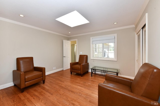 living area featuring a skylight, ornamental molding, and light hardwood / wood-style floors