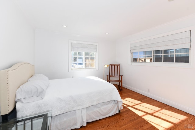 bedroom with hardwood / wood-style flooring and crown molding