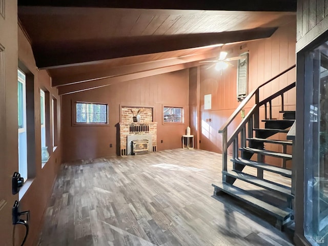 interior space featuring hardwood / wood-style floors, wooden ceiling, ceiling fan, lofted ceiling, and a fireplace