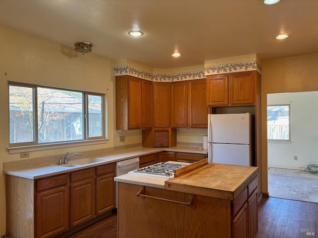 kitchen featuring sink, white appliances, dark hardwood / wood-style floors, and a kitchen island