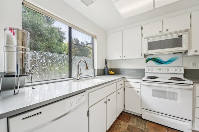 kitchen featuring sink, white cabinetry, and white appliances