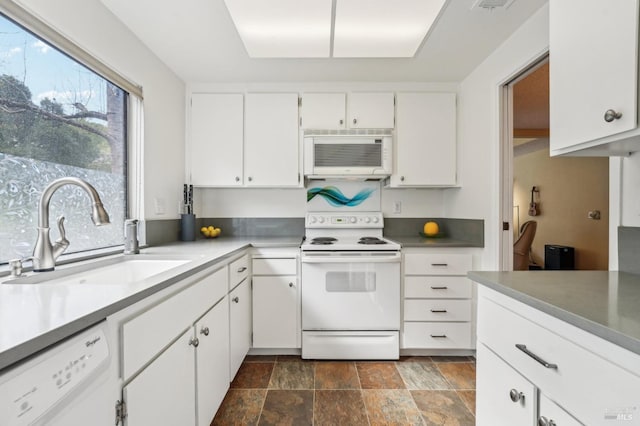 kitchen with sink, white appliances, and white cabinets