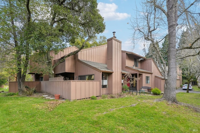 rear view of property featuring a lawn