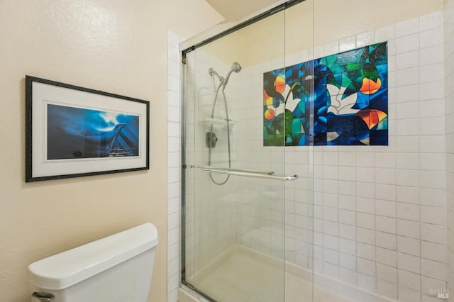 bathroom with toilet and an enclosed shower