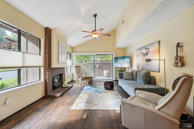 living room with ceiling fan, dark wood-type flooring, a textured ceiling, and lofted ceiling