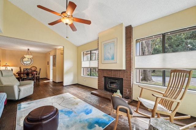 living room featuring lofted ceiling, dark wood-type flooring, ceiling fan, a textured ceiling, and a brick fireplace