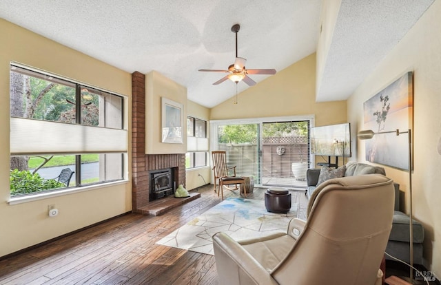 living room featuring ceiling fan, hardwood / wood-style floors, a textured ceiling, and vaulted ceiling