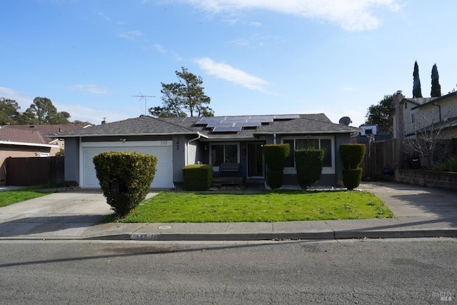 single story home with a garage, a front yard, and solar panels