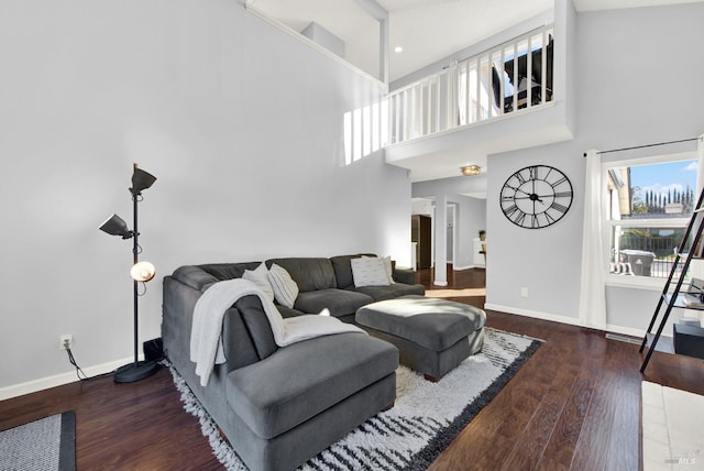 living room featuring dark hardwood / wood-style floors and a towering ceiling