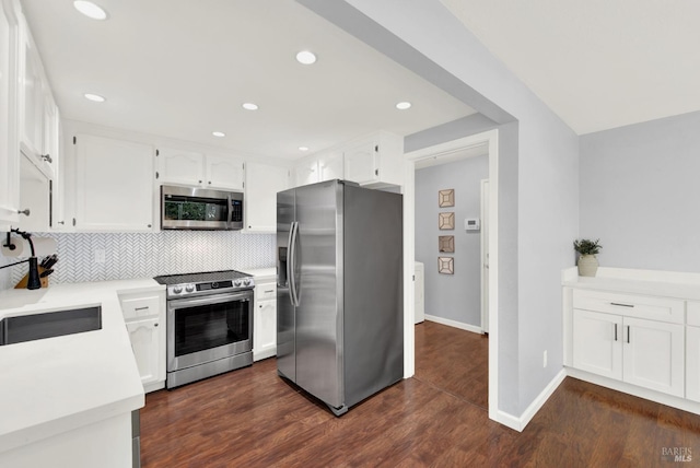 kitchen featuring white cabinets, stainless steel appliances, tasteful backsplash, sink, and dark hardwood / wood-style floors