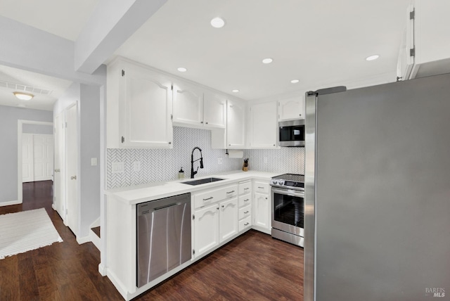 kitchen with dark hardwood / wood-style floors, appliances with stainless steel finishes, white cabinetry, and sink