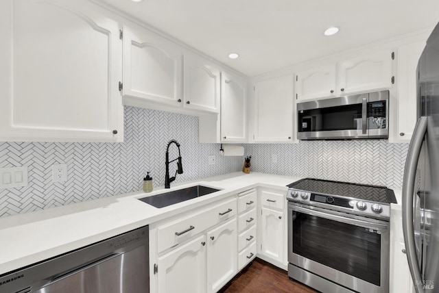 kitchen featuring white cabinetry, appliances with stainless steel finishes, tasteful backsplash, and sink