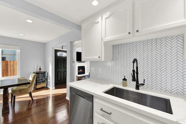 kitchen featuring decorative backsplash, sink, white cabinetry, and dishwasher