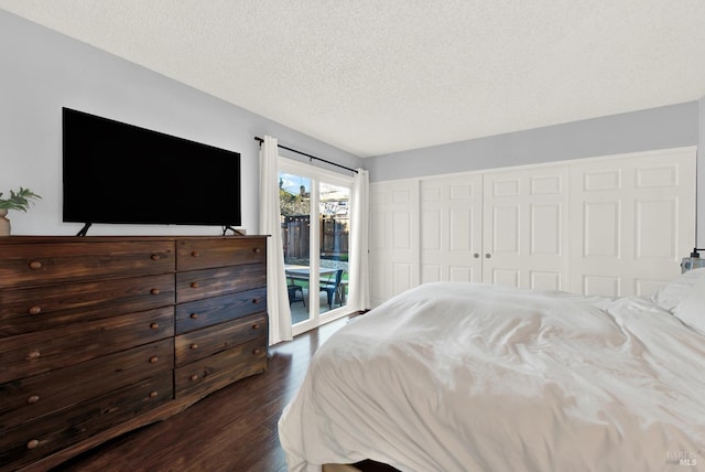 bedroom featuring a textured ceiling, dark hardwood / wood-style flooring, access to outside, and a closet