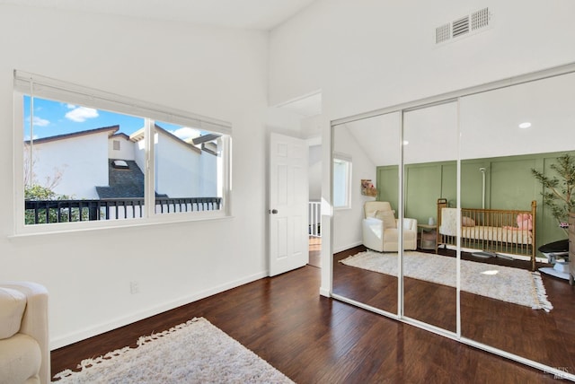 bedroom with a closet, vaulted ceiling, and dark hardwood / wood-style flooring