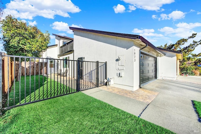 view of side of home with a balcony, a garage, and a lawn