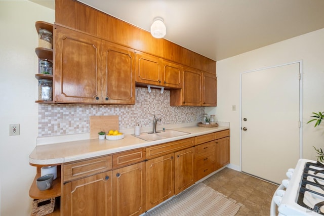 kitchen featuring sink, white gas stove, and backsplash