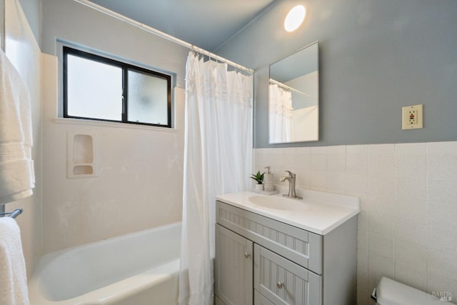 full bathroom featuring tile walls, vanity, toilet, and shower / bath combo with shower curtain