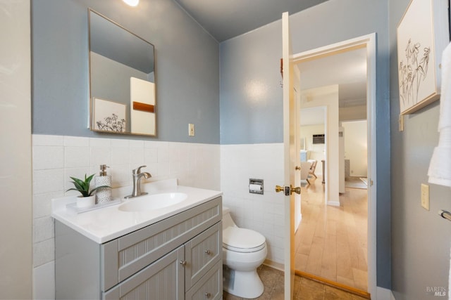 bathroom featuring vanity, toilet, tile patterned flooring, and tile walls