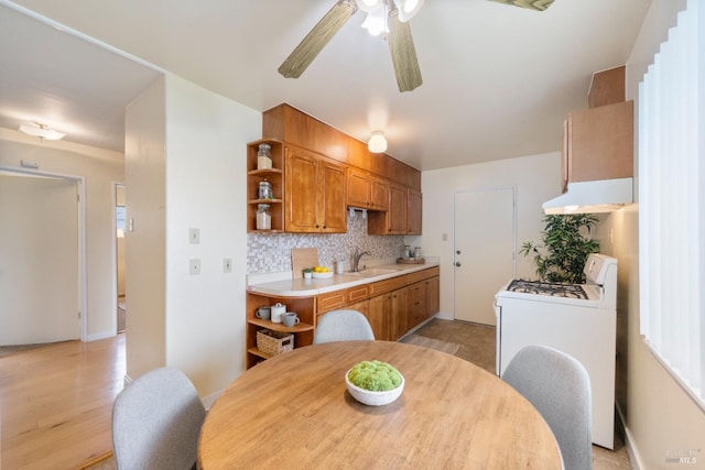 kitchen with washer / dryer, sink, ceiling fan, and decorative backsplash