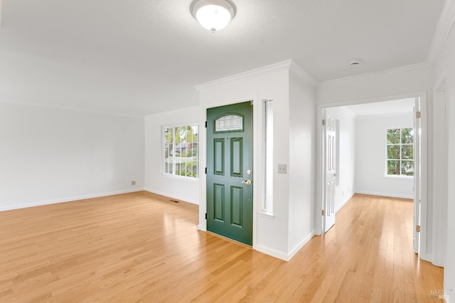 foyer with crown molding and light hardwood / wood-style flooring