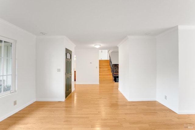 unfurnished room featuring ornamental molding and light hardwood / wood-style flooring